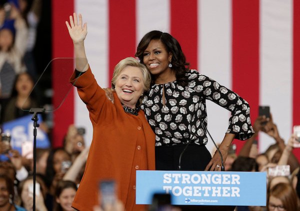 Democratic presidential candidate Hillary Clinton, accompanied by first lady Michelle Obama, greet supporters during a campaign rally in Winston-Salem, N.C., Thursday, Oct. 27, 2016. (AP Photo/Chuck Burton)